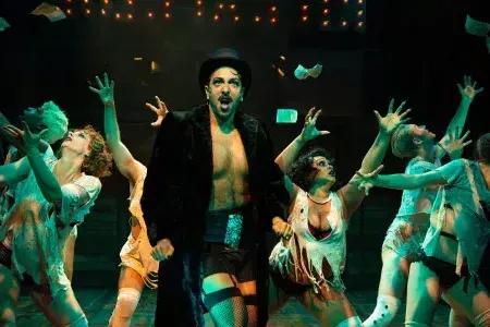 Performers try to catch floating money on stage during a production of Cabaret at the San Francisco Playhouse.